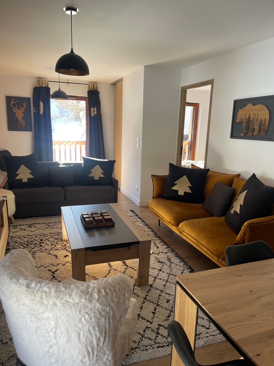 Salon avec canapés moutarde et grandes baies vitrées